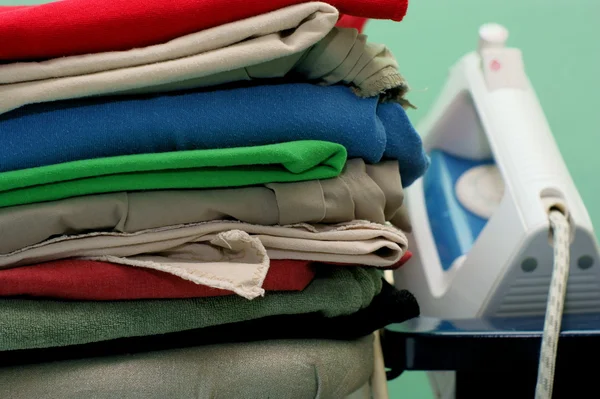 Pile of ironing on green background — Stock Photo, Image