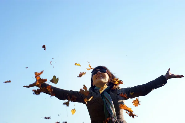 Mutlu bir kadın, kız atma güneşli autumnday üzerinde bırakır.. — Stok fotoğraf
