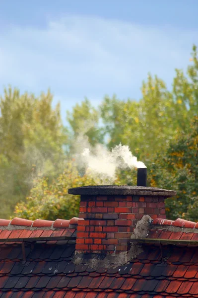 Uma velha chaminé e fumo numa casa privada — Fotografia de Stock