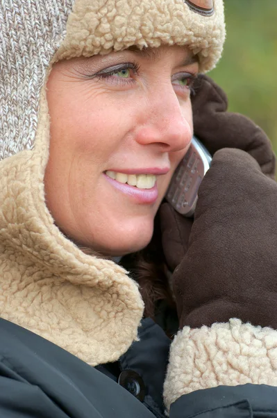 Woman talking on the telephone in warm winter clothes — Stock Photo, Image