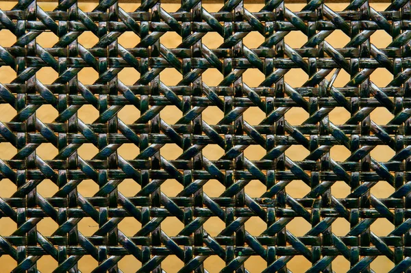 Close-up de padrão de vime tecido verde sobre laranja — Fotografia de Stock