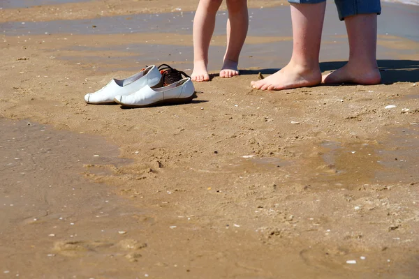 Buty na piaszczystej plaży. dzieci i mama nogi — Zdjęcie stockowe