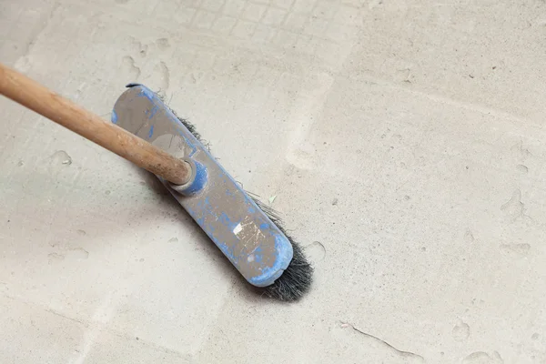 Betão duro em um local de trabalho usando uma vassoura grande — Fotografia de Stock