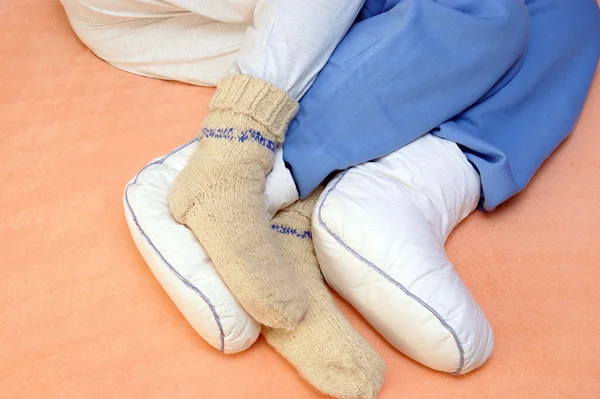 Two Couple's feet warming at a bed — Stock Photo, Image