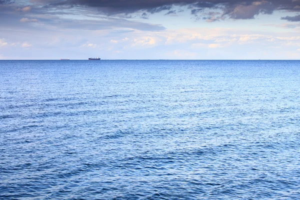 Cielo azul nublado que sale hacia el horizonte mar de superficie azul — Foto de Stock