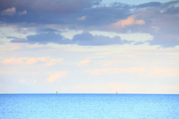 Cloudy blue sky leaving for horizon blue surface sea — Stock Photo, Image