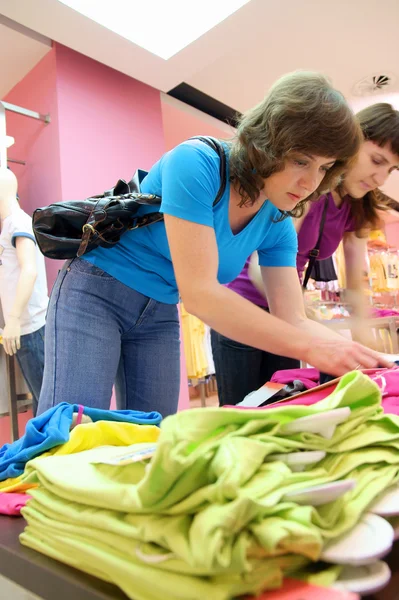 Dos mujeres comprando ropa en la tienda — Foto de Stock