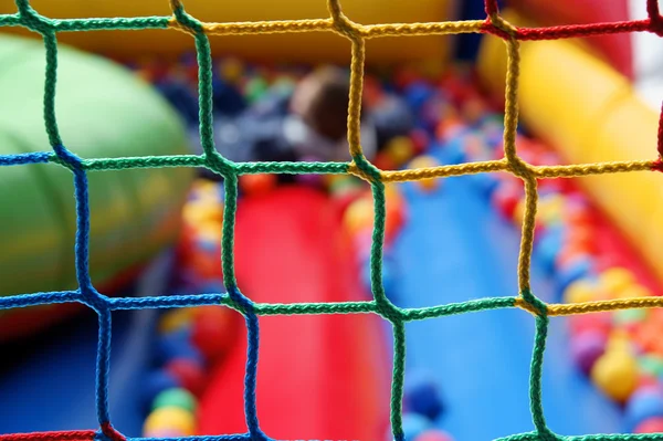 Zona de juegos peligrosa - cuidado de la salud de los niños que se divierten en la piscina de bolas — Foto de Stock
