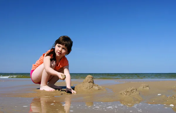 Kinderen maken zandkastelen op het strand, jong meisje spelen in het zand, — Stockfoto