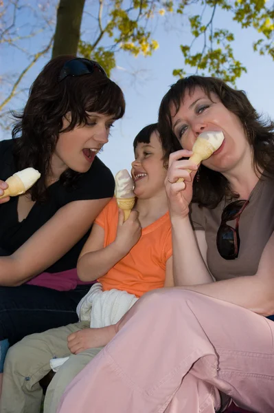Due donne e una bambina che mangiano gelato - gelato alla vaniglia. All'aperto — Foto Stock