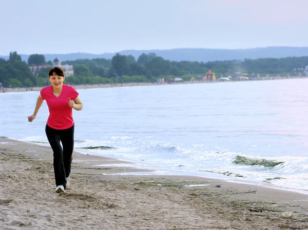 Jonge vrouw wordt uitgevoerd op een strand — Stockfoto