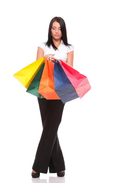 Retrato de mulher jovem carregando sacos de compras contra o bac branco — Fotografia de Stock