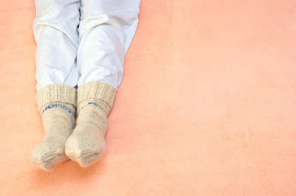 Frauenfüße wärmen sich am Bett — Stockfoto