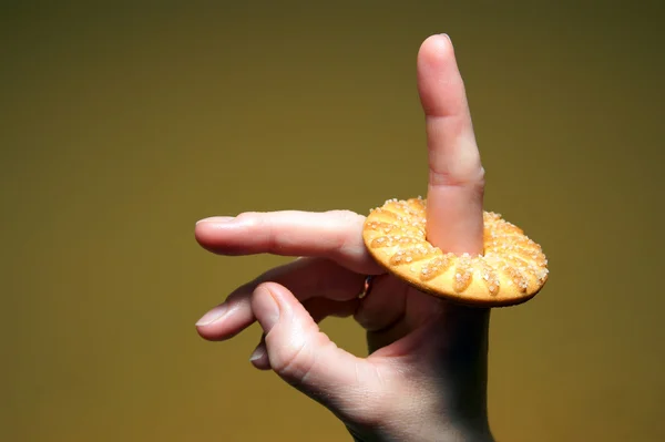 Cookies på ett finger på gul bakgrund — Stockfoto