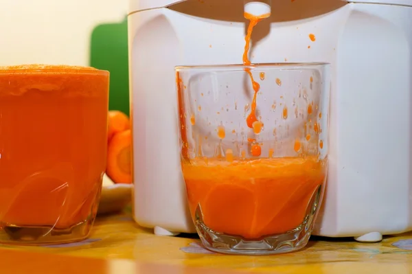 Morotsjuice i glas, juicer — Stockfoto