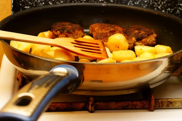 Fűszeres burgonya szeletet serpenyőben pan konyhában — Stock Fotó