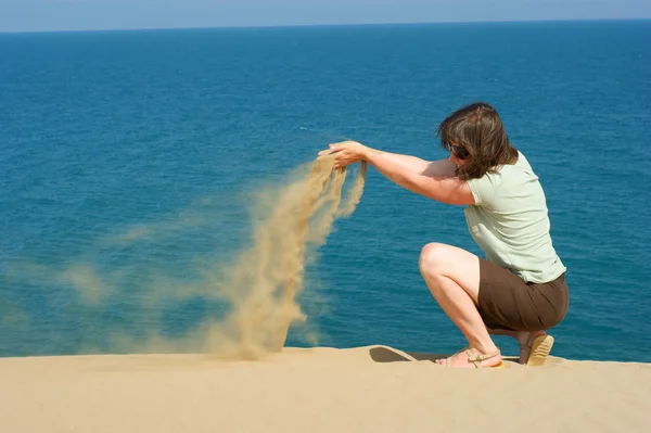 Femmes et sable sur une plage. Sable à la main féminine — Photo
