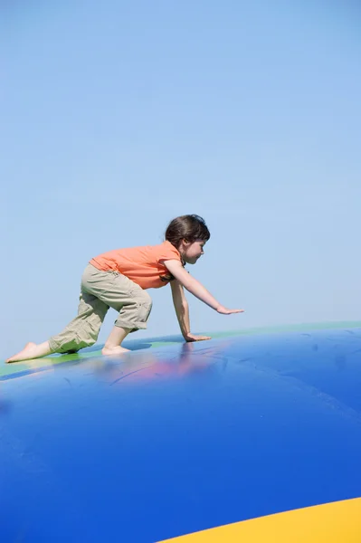 Girl jumping on the colored inflatable slide — Stock Photo, Image