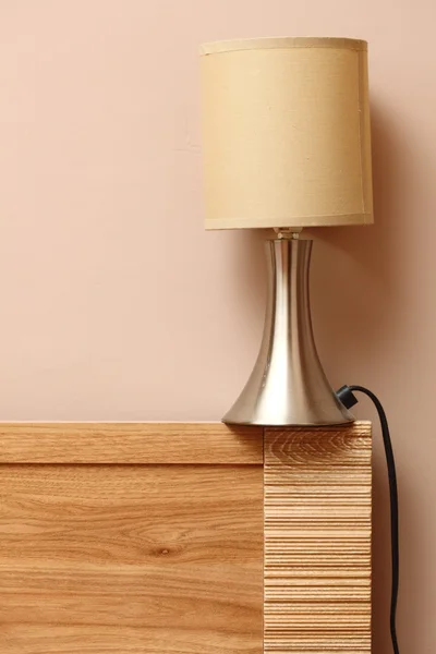 Lampa na straně dřevěná postel stěna pozadí — Stock fotografie