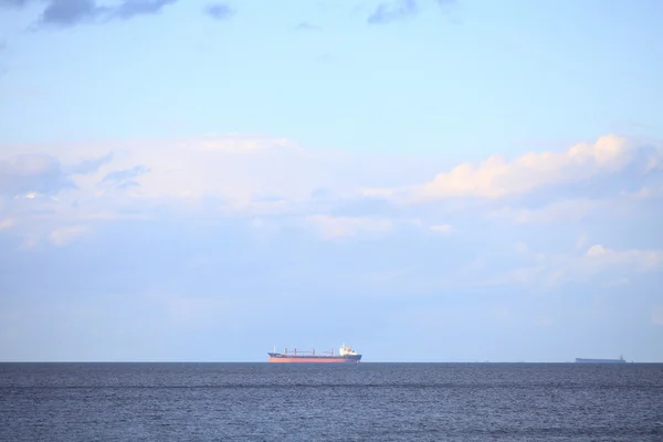 青い地平線の表面の海を残す曇りの青い空 — ストック写真