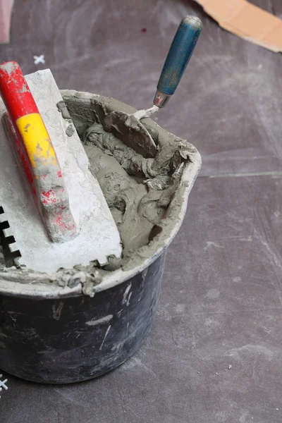 El trabajador de la construcción está embaldosando en el adhesivo de piso de baldosas —  Fotos de Stock