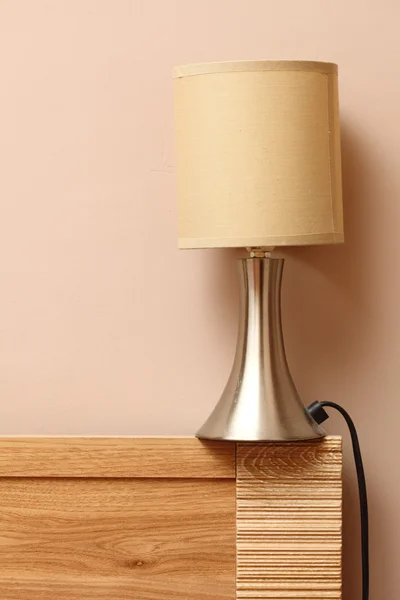 Lampe auf der Seite hölzerne Bett Wand Hintergrund — Stockfoto