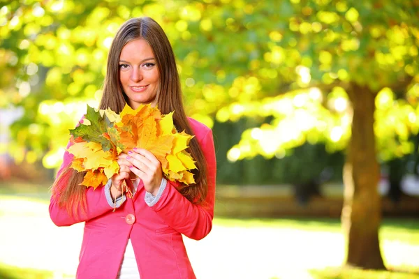 Podzimní žena na leafs pozadí — Stock fotografie