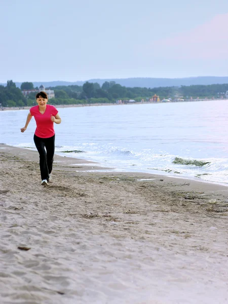 Jonge vrouw wordt uitgevoerd op een strand — Stockfoto