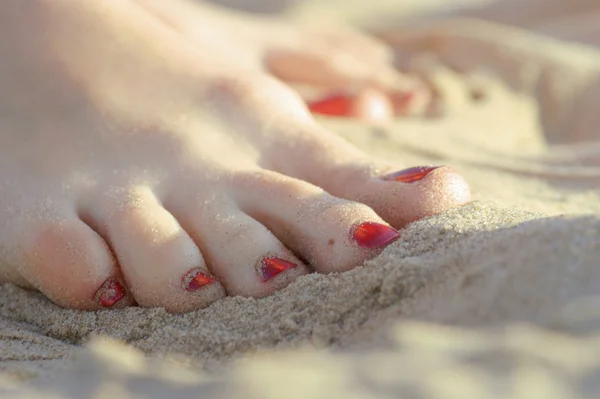 Women's feet wet in the sea sand — Stock Photo, Image