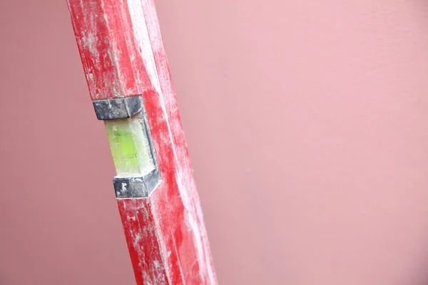 Level Construction worker home pink background — Stock Photo, Image