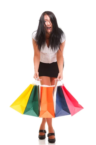 Portrait of young woman carrying shopping bags against white bac Stock Photo