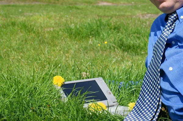 Cravate homme d'affaires et un ordinateur portable à l'extérieur dans une prairie — Photo