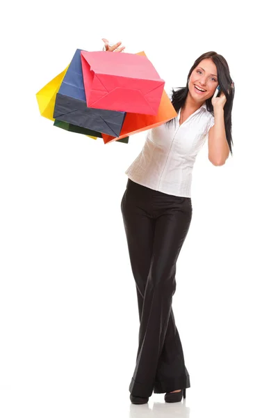 Retrato linda mujer joven con teléfono móvil mientras sostiene bolsas de compras —  Fotos de Stock
