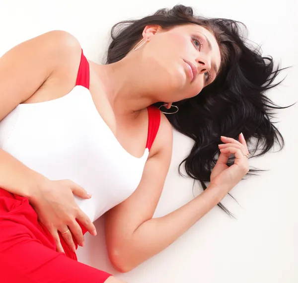 Latin woman in red lying on the floor white — Stock Photo, Image