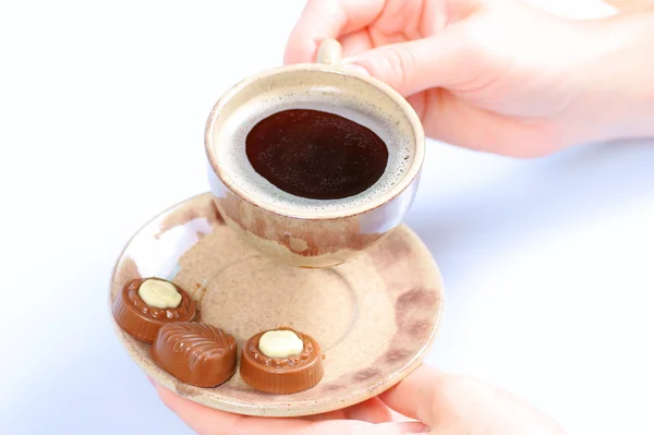 Chocolate pralines, cup, black coffee and female hand on white — Stock Photo, Image