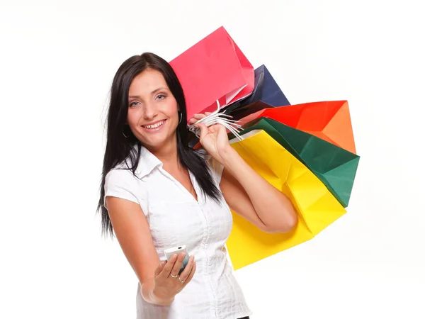 Portrait cute young woman mobile phone while holding shopping bags — Stock Photo, Image