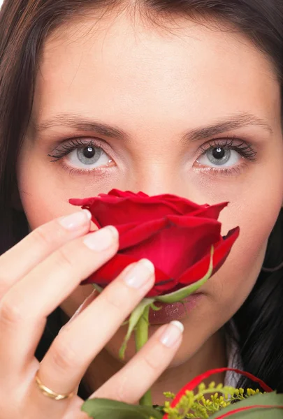 Portrait rapproché d'une jolie jeune femme tenant une rose rouge — Photo