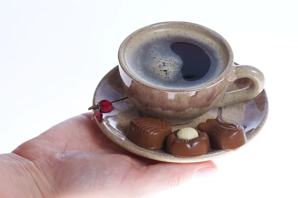 Pralinés de chocolate, taza, café negro y mano femenina sobre blanco —  Fotos de Stock