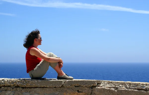 Relaxed woman in red blue sky and sea. — Stock Photo, Image