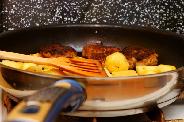 Fűszeres burgonya szeletet serpenyőben pan konyhában — Stock Fotó