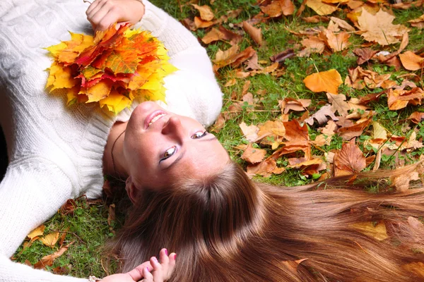 Herfst vrouw op gele bladeren in de hand achtergrond — Stockfoto