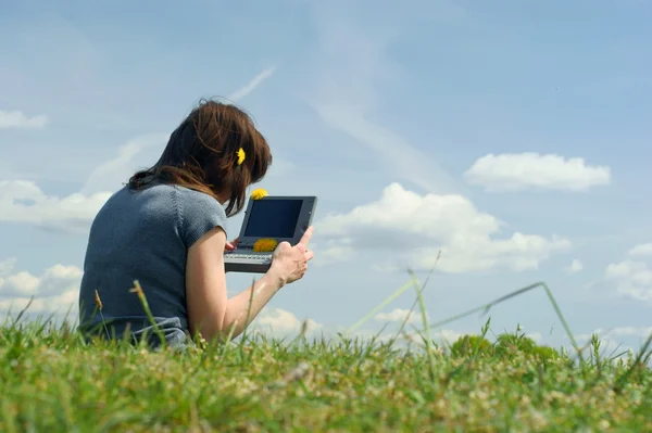 在一片草甸外便携式计算机上键入的女人 — 图库照片
