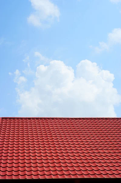 Красная крыша и голубое небо — стоковое фото