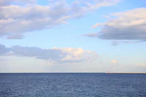 Cloudy blue sky leaving for horizon blue surface sea — Stock Photo, Image