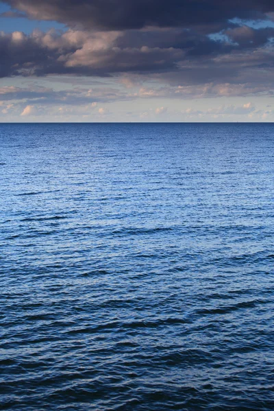 Molnig himmel lämnar för horizon blå yta havet — Stockfoto