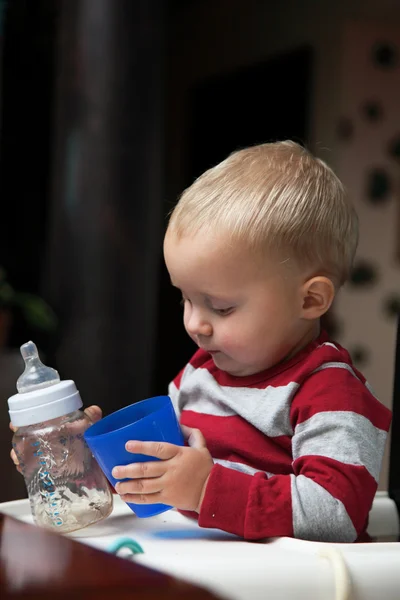 男の子のボトルとマグカップの屋内で遊ぶ — ストック写真