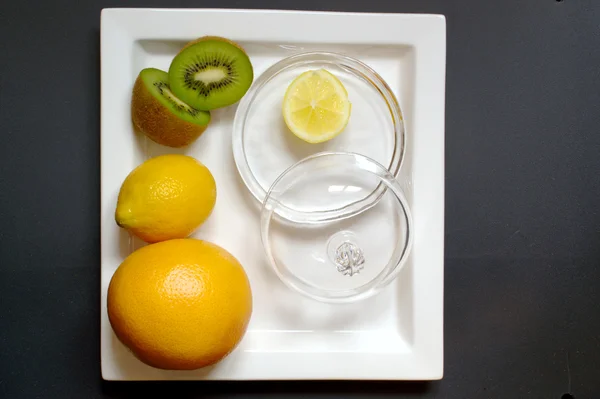 Apelsin, kiwi och citron på tallrik — Stockfoto