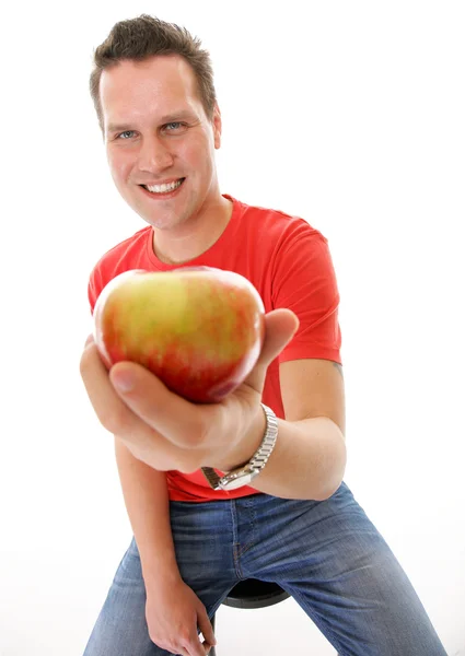 Knappe man in rode shirt met apple geïsoleerd — Stockfoto