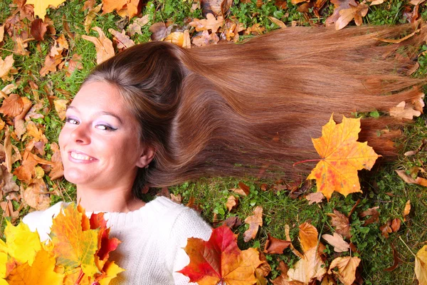 Podzimní žena na leafs pozadí — Stock fotografie