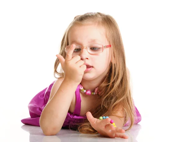 Fröhliche kleine Mädchen Brille zu zählen liegt isoliert — Stockfoto